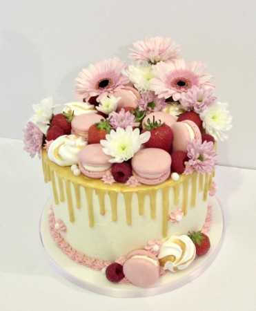 Drip cake with fresh flowers and macarons